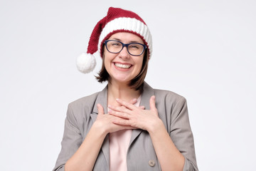 Manager woman in red Santa hat is touched by compliment or is happy to receive a gift.