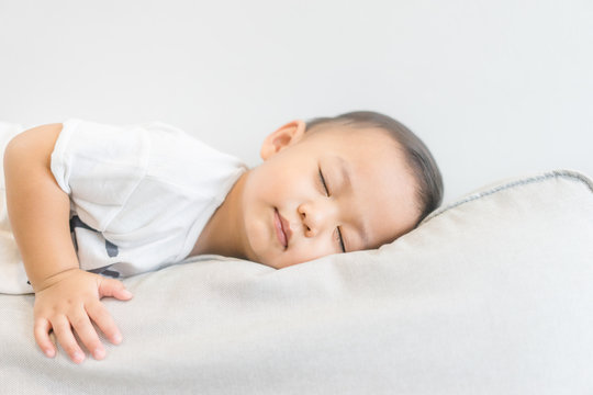Toddler boy sleeping in sofa and dream.Asian 2 years old baby boy sleep on the sofa in living room.Sleep time,Comfortable, peaceful and growth hormone concept.