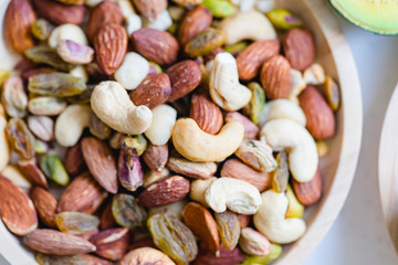 Nuts mix in a wooden plate.Mix nuts with almond, cashew, pistachio, and raisins.Concept of Healthy snack.Vegetarian and Ketogenic diet.