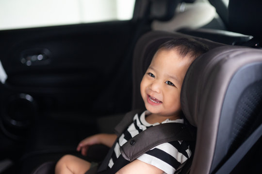 Transport, safety, childhood road trip and people concept - Happy baby boy sitting in baby car seat or booster seat, Child in auto baby seat in car, Asian boy in summer vacation to travel with family.