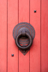 Detail of a red wooden church entrance door with a metalwork