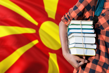 Macedonia national education concept. Close up of teenage student holding books under his arm with...