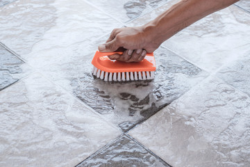 Men's hands are used to convert polishing cleaning on the tile floor.