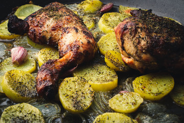Chicken with Potatoes, Onion and Baked Garlic on Wooden Table
