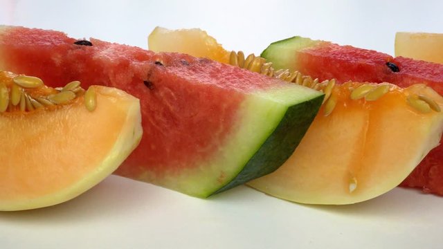 Juicy sliced ​​melon and watermelon on a white background. Slices are on the table.