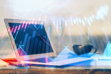 Stock market graph on background with desk and personal computer. Double exposure. Concept of financial analysis.