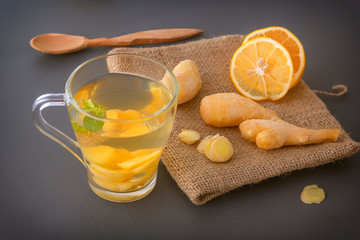Ginger tea with lemon and mint on a gray wooden table. Close-up