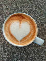 cup of coffee with red heart on wooden table