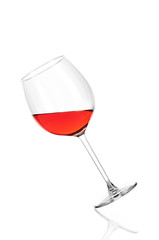 A glass of rose wine half filled, isolated on a white background. The glass is tilted to the left.