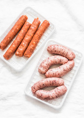 Raw uncooked turkey and spicy smoked paprika pork homemade sausages on light background, top view. Food ingredients