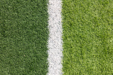 Fototapeta premium White stripe on the green soccer field from top view