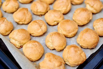 profiteroles, custard cake on a table with tea