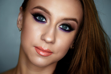 Portrait of a young woman with beautiful evening make-up on a dark background