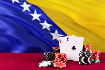 Bosnia Herzegovina casino theme. Aces in poker game, cards and chips on red table with national flag background. Gambling and betting.