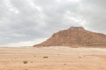 Desert, red mountains, rocks and cloudy sky. Egypt, color canyon.