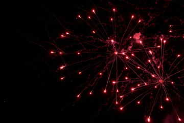 Fototapeta premium Night sky salute. A photo of a salute in the sky. Abstract salute texture. Texture of bright lights, abstract figures in the sky. Multicolored flares of lights. Photo for textures and processing