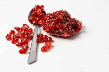 Fresh ripe pomegranate on white background, Spoon with fresh pomegranate seeds.