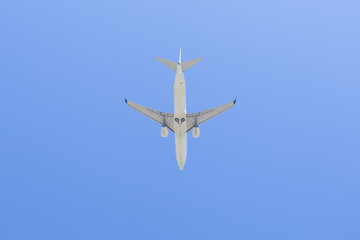 Commercial airline flying on blue sky under view.