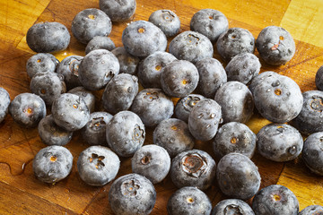 Pile of freshly washed blueberries on a wooden board. Fresh, healthy food_