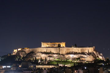 Night view of acropolis building on a hill with lights and beautiful scenery in Athens Greece