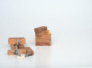 Miniatures as workers are working for wooden block. Construction concept.
