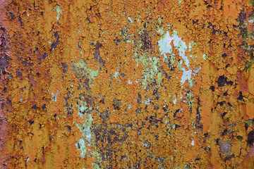 Rusty metal texture background. Old worn iron door with peeled off orange paint. Close up, copy space