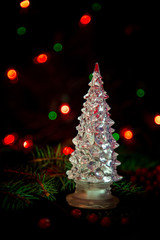 Christmas toys, with green Christmas tree on dark background with lights