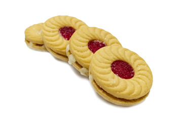 Biscuit sandwich butter cookies with cream and strawberry flavoured jam. A stack of crunchy delicious sweet meal and useful cracker. isolated on white background. Soft focus.