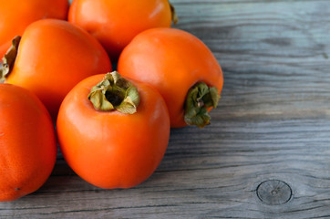 Fresh ripe organic Persimmon or Kaki fruit on old wooden table. Diospyros kaki.Healthy food vegetarian or raw diet concept.Copy space.Selective focus.