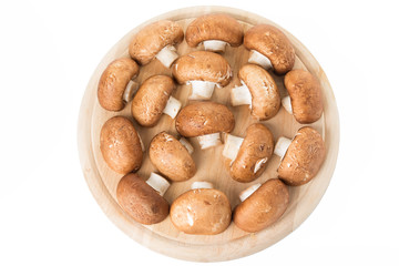 Group of brown mushrooms on a cutting board.