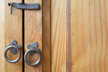close-up of Mexican style of furniture, showing aged wood, iron lock handle and knobs in rings. 