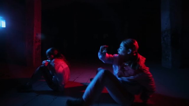 duet of young beautiful girls dancing hip hop, street dancing in the studio on a black background, isolated