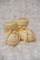 Small knitted yellow booties for the newborn.