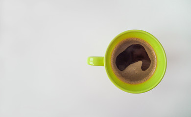green cup of coffee on white or gray background, top view, copy space