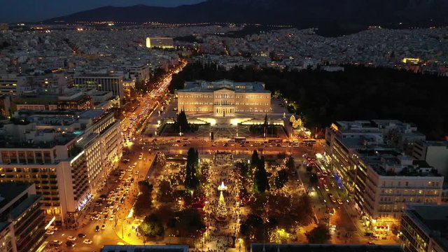Aerial drone video of illuminated festive Syntagma square featuring Greek Parliament and Christmas tree, Athens centre, Attica, Greece