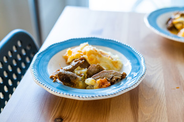 Homemade Turkey Meat with Potato Puree in Plate on Wooden Table at Kitchen.