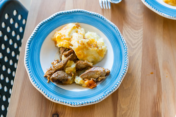 Homemade Turkey Meat with Potato Puree in Plate on Wooden Table at Kitchen.