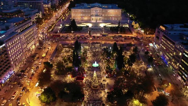 Aerial drone video of illuminated festive Syntagma square featuring Greek Parliament and Christmas tree, Athens centre, Attica, Greece
