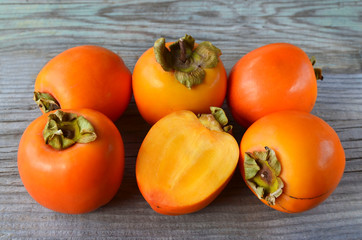 Fresh ripe organic Persimmon or Kaki fruit on old wooden table. Diospyros kaki.Healthy food vegetarian or raw diet concept. 