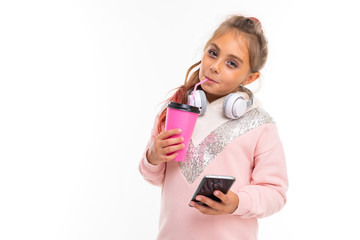 Fashionable teenager girl in pink hoody plays in phone games