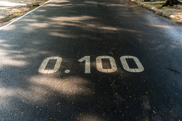 Marking distance sign on asphalt road in the Park