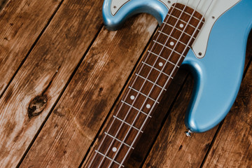 A placid blue electric bass on a wooden background