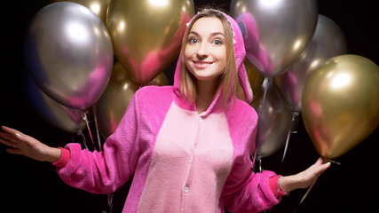 girl in pink kigurumi pajamas with balloons. pajama party