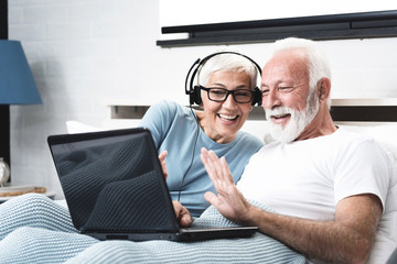 Elderly retired couple talking over the camera, skype call