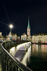 Obraz premium Münsterbrücke und Fraumünster bei Nacht, beleuchtetes Stadthaus und Zunft zur Meisen, Wasserspiegelung in der Limmat, Hochformat