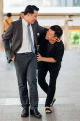 Full Length Of Smiling Businessmen With Man Walking On Bridge