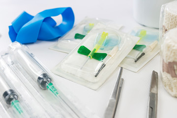 Fototapeta premium Medical kit with vials, syringes, compression gum, tweezers and surgical scissors with bends on a nursing table for emergency assistance