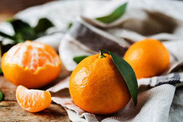 Tangerine fruit with slices, peel and leaves
