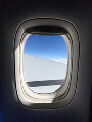 Fototapeta premium Airplane window with blue sky background