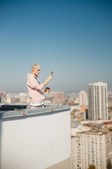 Young male making photo on the rooftop